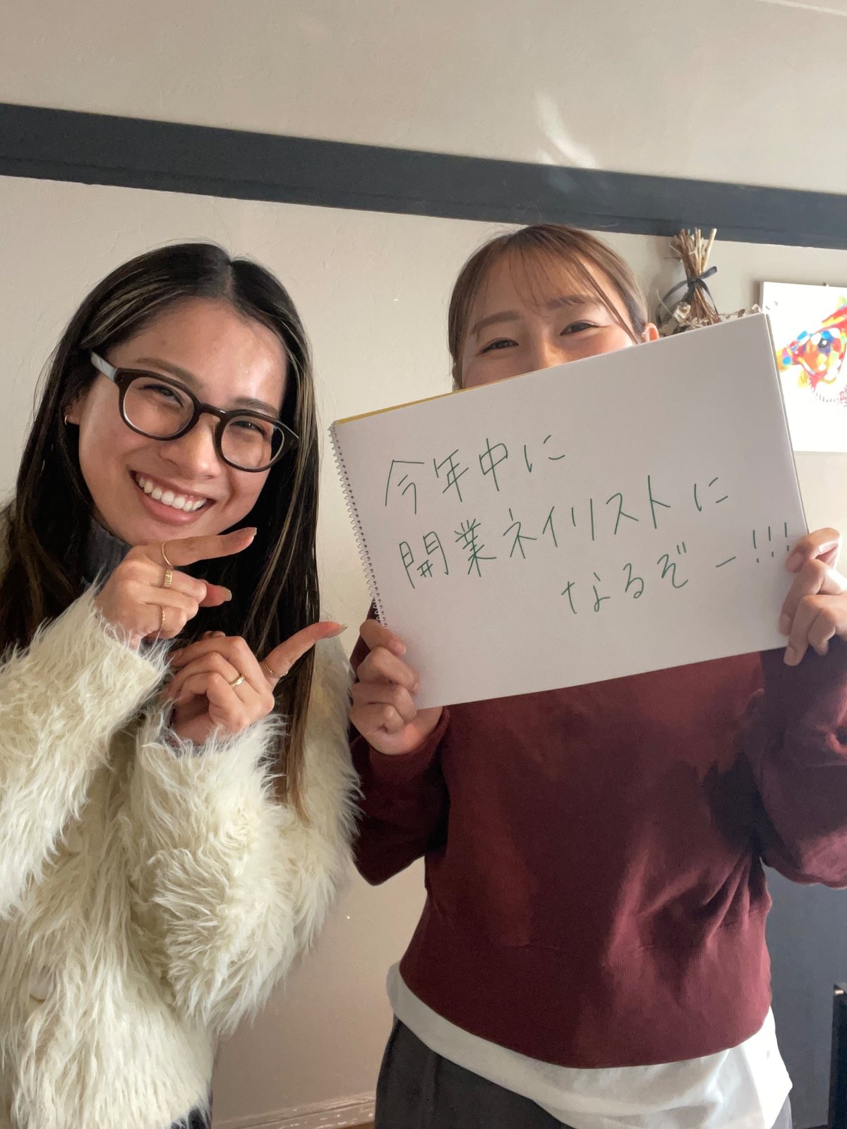 「今年中に開業ネイリストになるぞー!!!」と書いたボードを持つ、airiと生徒さん
